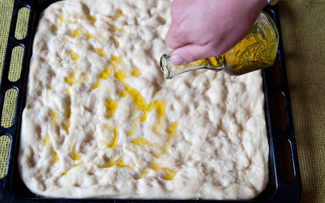 L'olio extravergine di oliva versato sulla focaccia genovese
